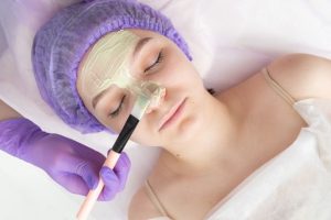 Mor boneli güzel kadına kil maskesi yapılıyor