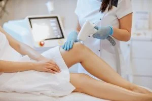 Mavi eldivenli doktor epilasyon tedavisi yapıyor