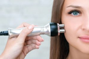 İpek kirpik yapılmış kadının yüzüne radyofrekans işlemi yapılıyor