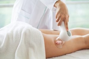 Hasta bacağına selülit karşıtı masaj yaptırıyor